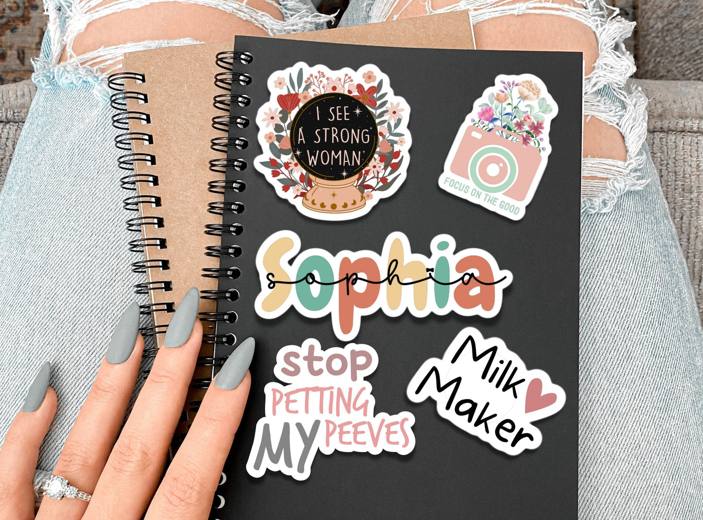 a person holding a notebook with stickers on it