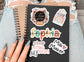 a person holding a notebook with stickers on it